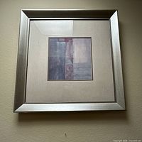Front view of square framed abstract geometric print with silver frame and mat