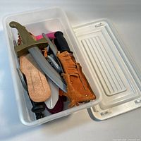 Daggers and sheaths inside storage bin