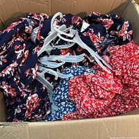 Box with multiple dresses and hangers visible