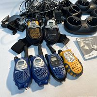 Overall lot showing six radios, four charging cradles, power cords, holsters, manual and clips