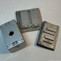 Group shot showing two Red Dot covers, three Mason covers, and one steel outlet box