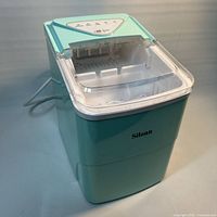 Front view of Silonn ice maker showing mint body, clear lid and logo