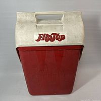 Front view of red cooler with white flip-top lid and handle