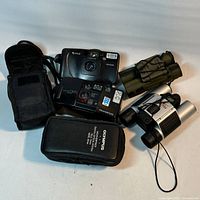Group view of two cameras, binoculars, pouches