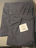 Folded dark navy 5.11 Tactical Series women’s pants with knee pads visible, size tag card shown