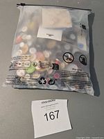 Front view of sealed bag filled with assorted buttons