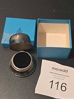 Ring box open showing velvet interior beside blue Birks box