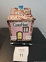 Front view of ceramic house cookie jar with lid on