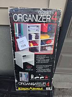Front of sealed Stack A Shelf Closet Organizer 4 box showing product image and model info