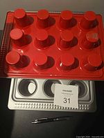 Top view showing red underside of first tray with raised cup bases
