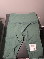 Full view of green Knix leggings laid flat