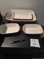 All four nested red and white Lagostina baking dishes on table