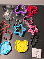 Group of twelve assorted cookie cutters in various colors and materials