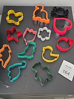 Overview of 13 assorted plastic cookie cutters on surface