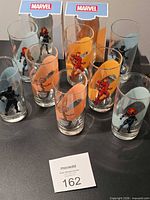 Group shot of all eight Marvel glasses with two branded boxes visible