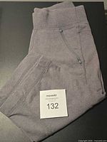 Folded heathered grey Lululemon cropped pants showing waistband, seams, and zip pocket