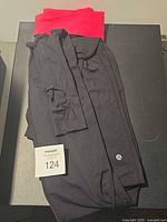 Full view of folded black leggings with red waistband