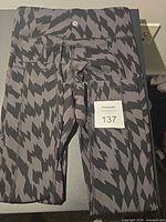 Folded Lululemon grey and black patterned leggings showing logo and size sticker