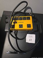 Top view showing eight outlets, breaker switch, cord and plug