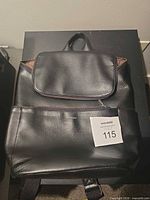Front view of black vegan leather Matt & Nat backpack with flap pocket and lot tag