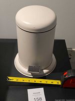 Full view of trash can with tape measure for scale
