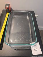 Top view of clear glass Pyrex rectangular baking dish with measuring tape showing length