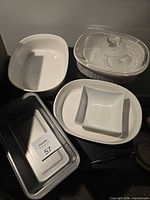 Group shot all five dishes on table: CorningWare casseroles, clear lid, oval baker, square bowl, loaf pan