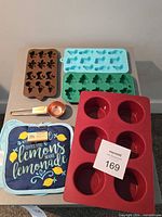 All items overview on table: four silicone molds, copper scoop, packaged pot holders