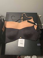 Front view of colorblock bra showing cups, logo emblem, hanger, and condition