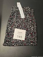 Folded black leggings with holiday pattern, SweetLegs tag visible