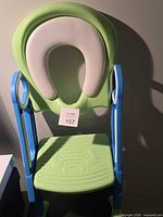 Front view showing full toilet training seat, ladder sides, foot platform, cushioned seat