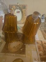 Two amber ribbed bell glass lamp shades standing upright