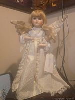 Full view of porcelain angel doll standing on surface