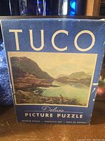 Front of TUCO puzzle box showing brand and landscape image