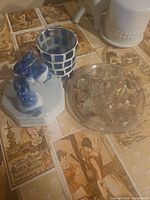 Overall lot with porcelain rabbit figurine, small blue white vase, clear glass flower frog