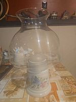 Lamp assembled showing ceramic base floral pattern and clear glass globe chimney