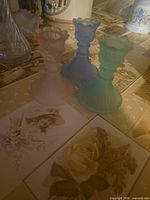 Three colored frosted glass candlestick holders on table