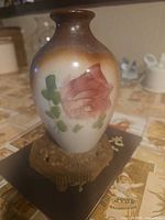 Front view of porcelain vase showing floral painting and color gradient