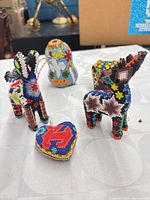 Group shot of four Huichol beaded items