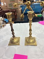 Front view of both brass candlestick holders on table