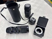 Group view of three lenses, adapter and lens case