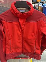 Front view of red Patagonia child jacket on hanger