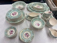 Overview of dinnerware set showing stacks of plates, bowls, platters, gravy boat, creamer and cups