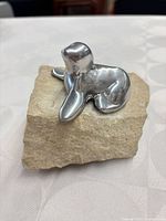 Front view of aluminum seal sculpture on stone block