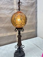 Full view of lamp showing globe shade, metal column and base