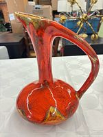 Full view of ceramic pitcher showing shape, handle and glaze pattern