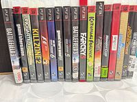Spines of 17 PS3 game cases lined up on a table
