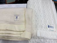 Both blankets folded showing labels and satin bindings