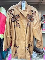 Front view of caramel leather jacket with floral appliques