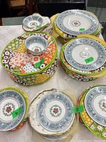 Stacks of Wedgwood Florentine plates, teacup and fabric cases with quantity labels